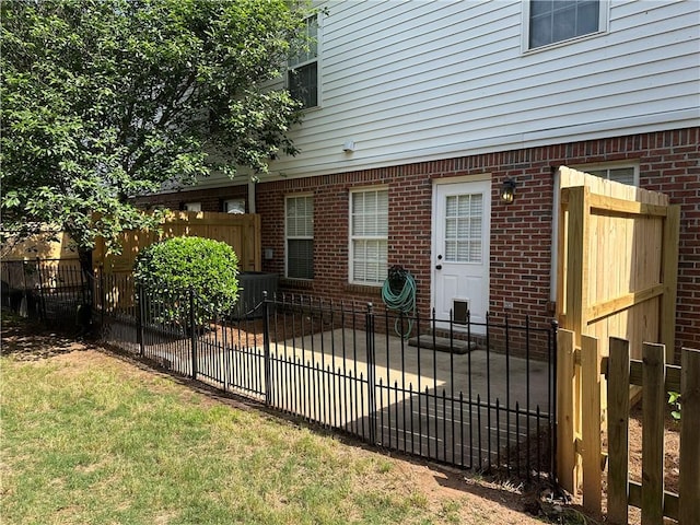 view of property exterior with brick siding, view of scattered trees, a shingled roof, and ceiling fan