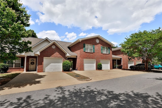 view of front of property featuring driveway, brick siding, and a garage