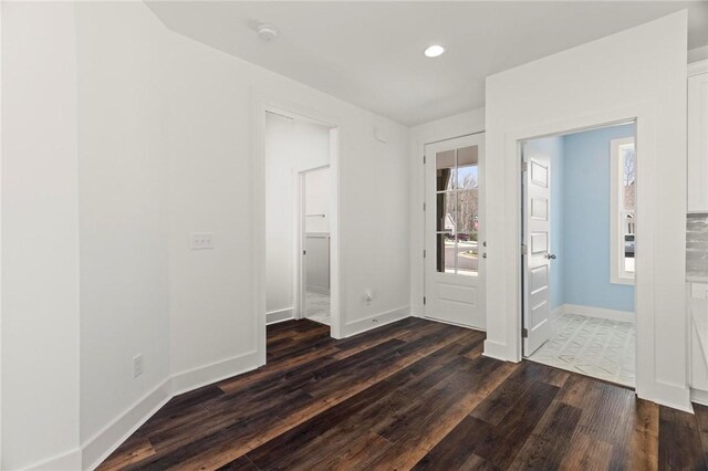 foyer featuring recessed lighting, baseboards, and dark wood-type flooring