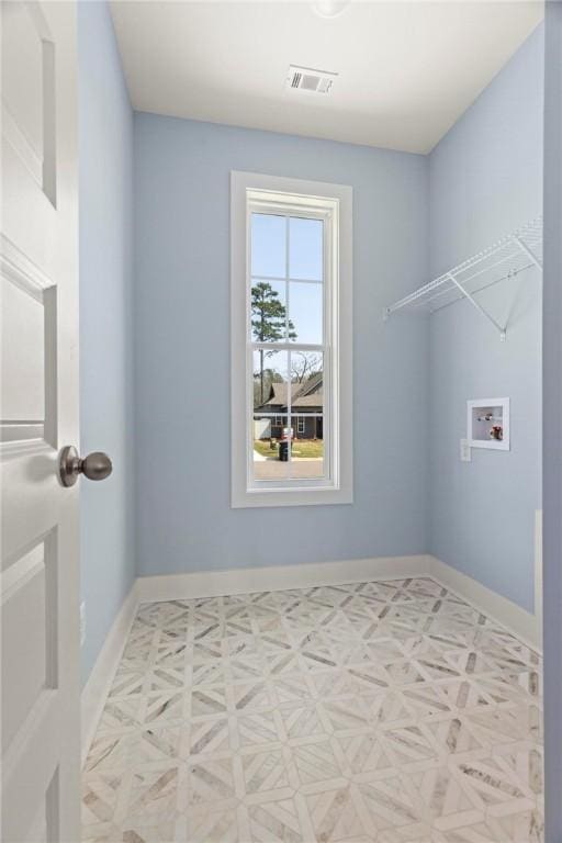 clothes washing area with visible vents, baseboards, hookup for a washing machine, and laundry area