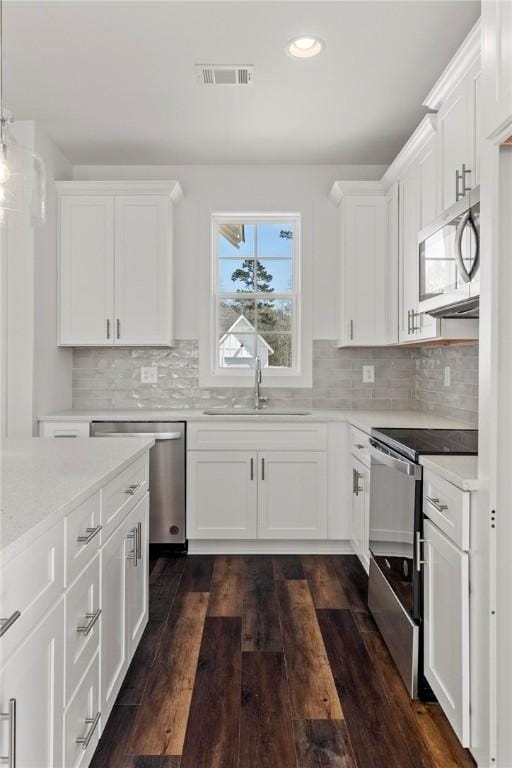 kitchen featuring visible vents, a sink, stainless steel appliances, white cabinets, and light countertops