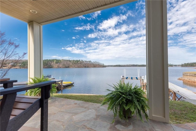 view of patio featuring a water view and a dock