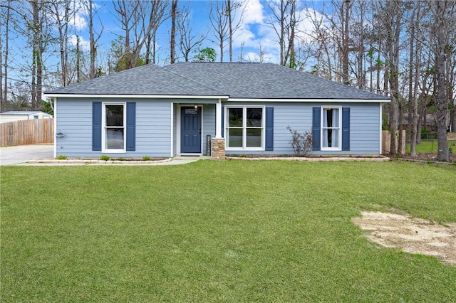 single story home with a front lawn, a shingled roof, and fence