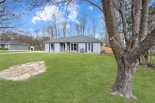 single story home with a front lawn, a shingled roof, and fence