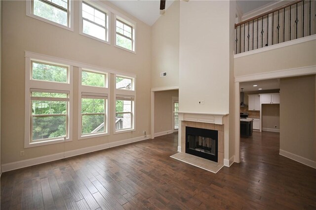 2228 Morgan Dr, Auburn, AL 36830 - unfurnished living room with a high ceiling, baseboards, dark wood-type flooring, and a tile fireplace