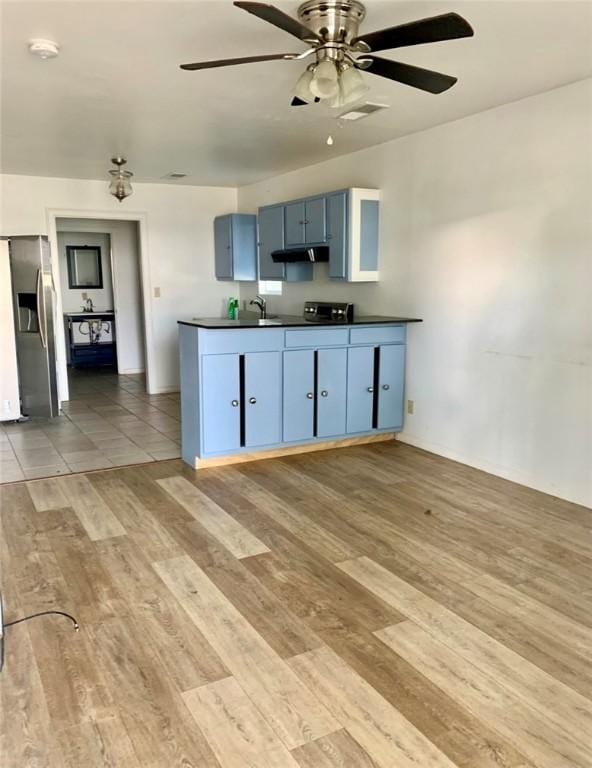 kitchen featuring blue cabinetry, stainless steel fridge with ice dispenser, sink, and wood-type flooring