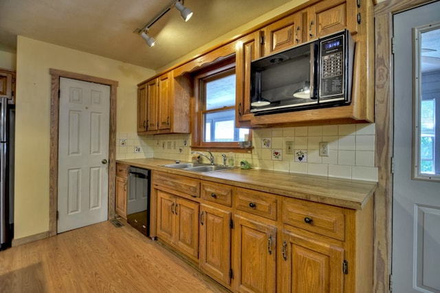 kitchen with track lighting, tasteful backsplash, sink, light hardwood / wood-style flooring, and black appliances