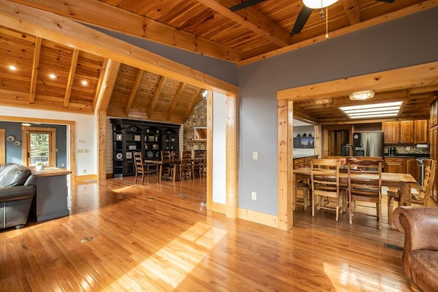 living room with lofted ceiling with beams, sink, light wood-type flooring, and wooden ceiling