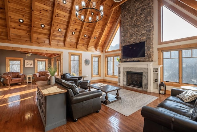 living room featuring wood-type flooring, high vaulted ceiling, wooden ceiling, beamed ceiling, and a fireplace