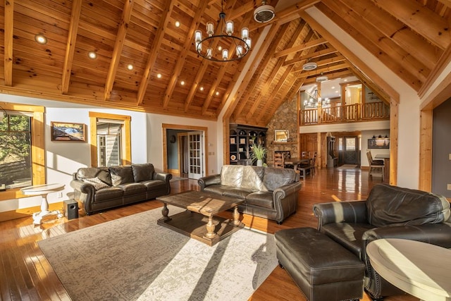 living room featuring wood ceiling, hardwood / wood-style flooring, an inviting chandelier, beam ceiling, and high vaulted ceiling