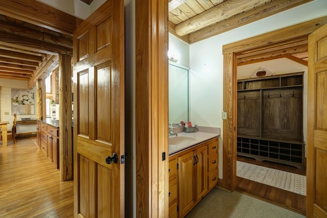 bathroom with beamed ceiling, vanity, hardwood / wood-style floors, and wooden ceiling