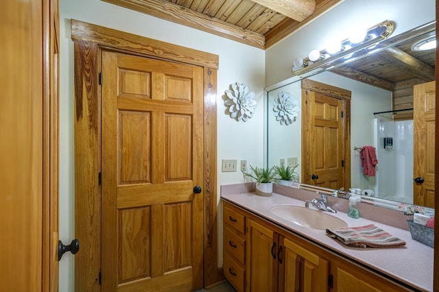 bathroom featuring wood ceiling, beamed ceiling, vanity, and a shower