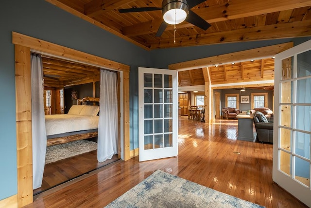 interior space with hardwood / wood-style floors, lofted ceiling with beams, ceiling fan, wood ceiling, and french doors