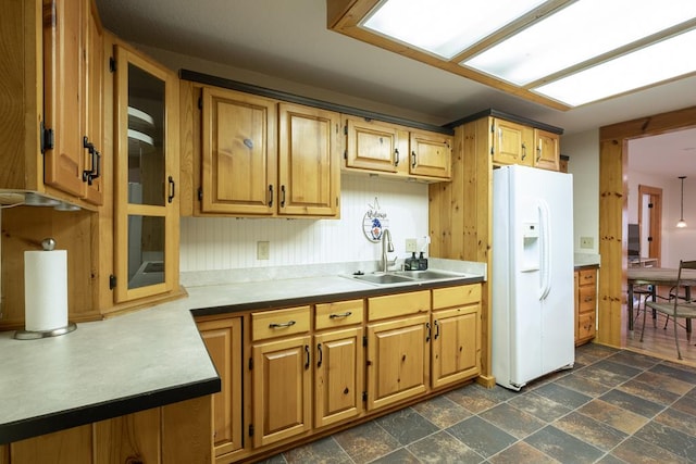 kitchen featuring white refrigerator with ice dispenser and sink