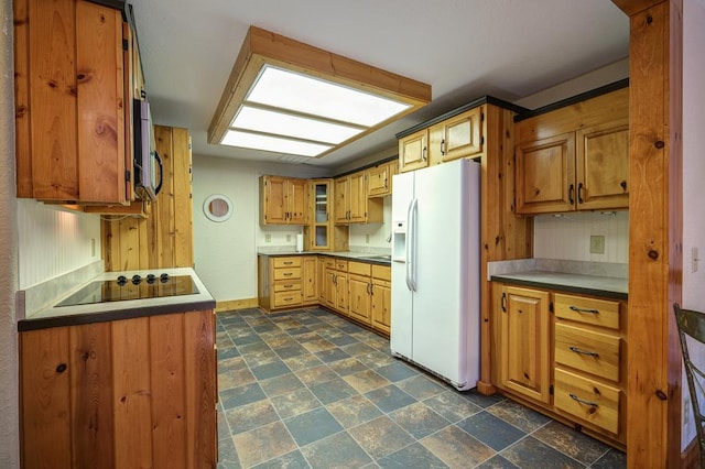 kitchen featuring black electric cooktop and white fridge with ice dispenser