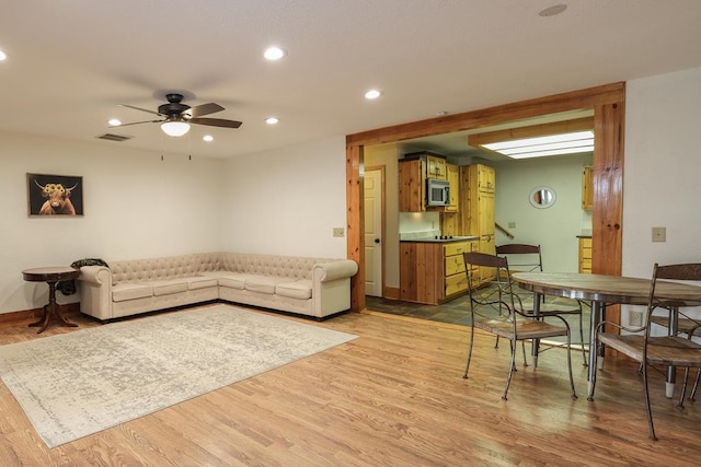 living room with hardwood / wood-style flooring and ceiling fan