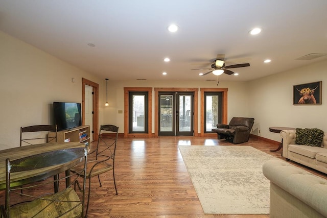 living room with light hardwood / wood-style flooring, french doors, and ceiling fan