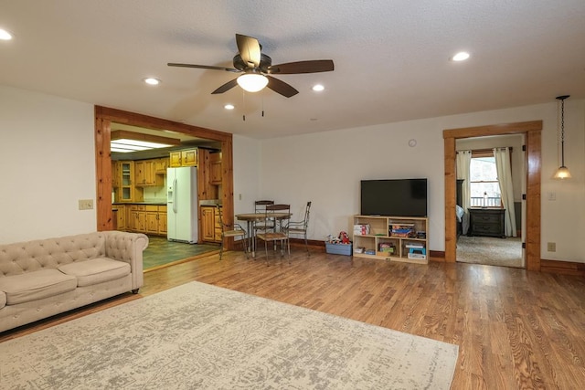 living room with hardwood / wood-style floors and ceiling fan