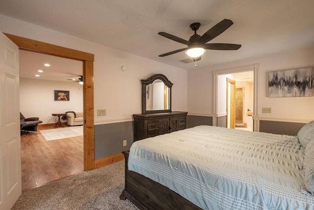 bedroom featuring hardwood / wood-style floors, ensuite bath, and ceiling fan