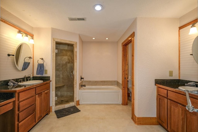 bathroom with vanity and shower with separate bathtub