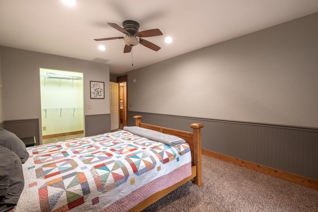 carpeted bedroom featuring ceiling fan and ensuite bath