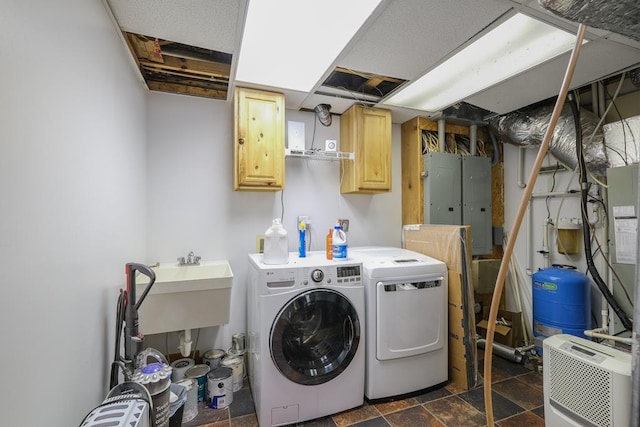 laundry room featuring electric panel, cabinets, and washing machine and clothes dryer