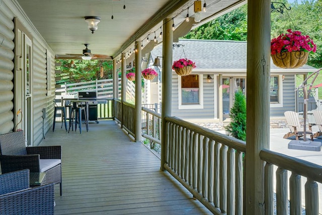 deck featuring area for grilling, covered porch, and ceiling fan