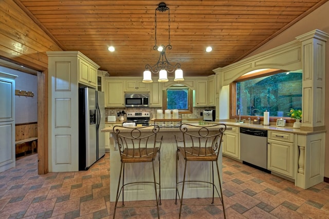 kitchen featuring hanging light fixtures, a center island, stainless steel appliances, and vaulted ceiling