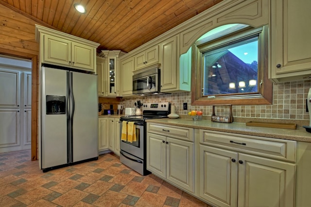 kitchen with tasteful backsplash, cream cabinetry, appliances with stainless steel finishes, and wooden ceiling