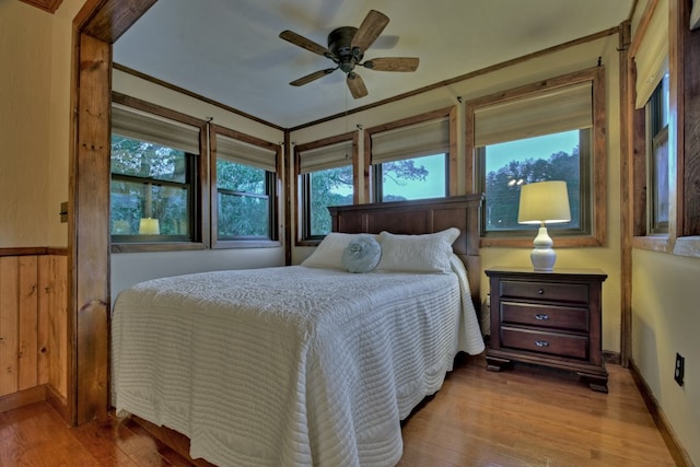 bedroom featuring ceiling fan, light wood-type flooring, and multiple windows