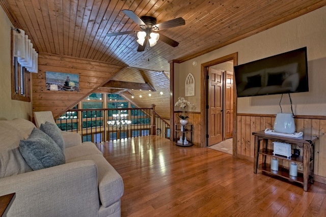 living room with ceiling fan, wood ceiling, and wood walls