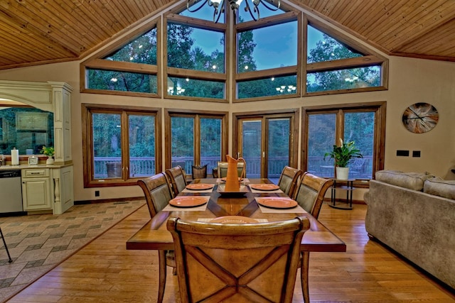 dining room with an inviting chandelier, light hardwood / wood-style floors, and high vaulted ceiling