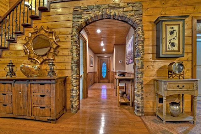 hallway featuring hardwood / wood-style flooring, rustic walls, and wood ceiling