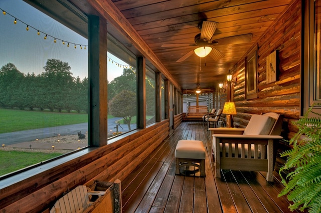 unfurnished sunroom with ceiling fan, wooden ceiling, and a wealth of natural light