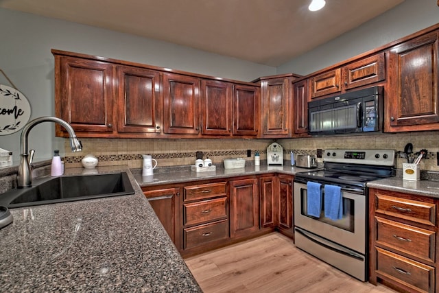 kitchen featuring electric stove, light hardwood / wood-style flooring, sink, and tasteful backsplash