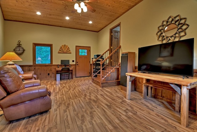 living room with ceiling fan, wood walls, crown molding, light hardwood / wood-style flooring, and wood ceiling