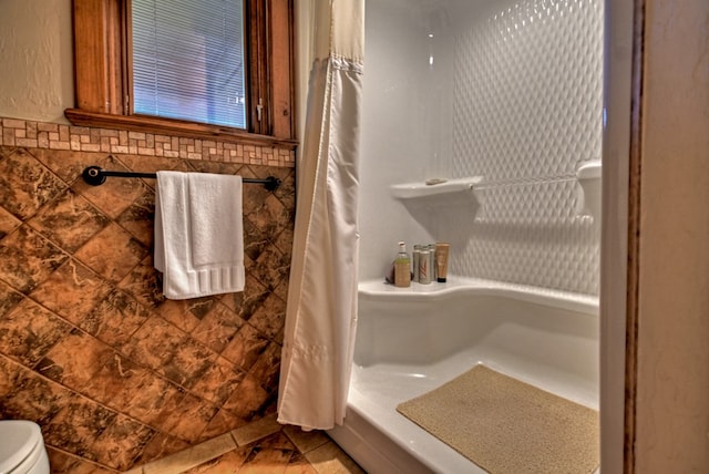 bathroom featuring curtained shower and tile walls