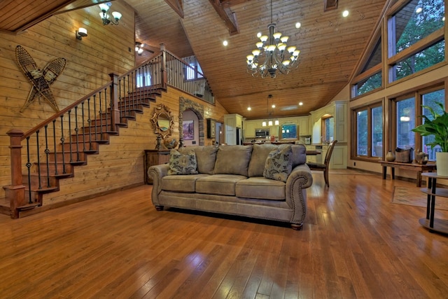 living room with wooden walls, hardwood / wood-style flooring, high vaulted ceiling, a chandelier, and wooden ceiling