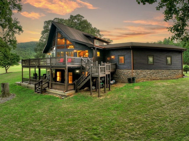 back house at dusk with a deck and a yard