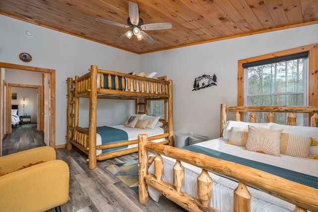 bedroom with lofted ceiling, dark wood-type flooring, ceiling fan, ornamental molding, and wood ceiling