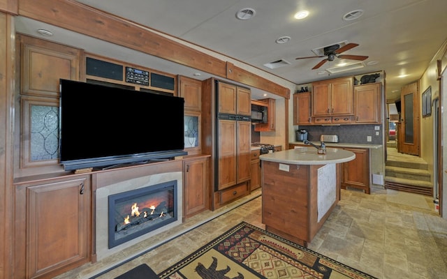 268 Getaway Holw, Hayesville, NC 28904 - kitchen with brown cabinets, light countertops, black microwave, a kitchen island with sink, and a fireplace