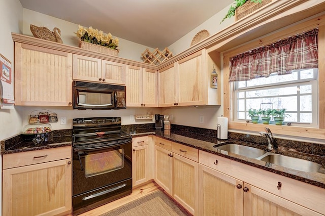 kitchen with black appliances, light brown cabinets, sink, and dark stone countertops