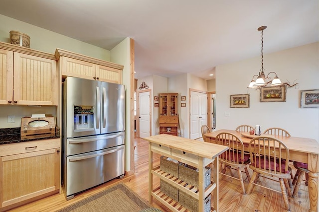 kitchen featuring stainless steel fridge with ice dispenser, an inviting chandelier, light brown cabinets, and decorative light fixtures