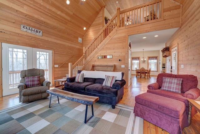 living room featuring plenty of natural light, wood walls, and high vaulted ceiling