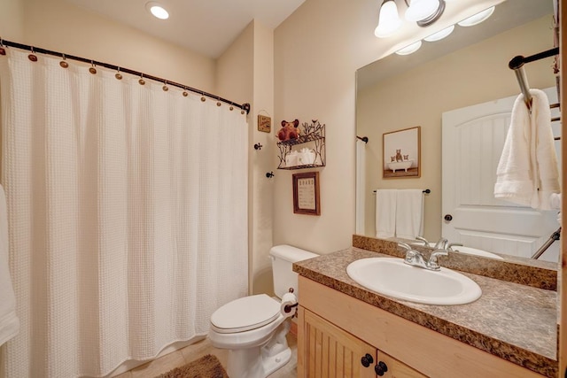 bathroom featuring toilet, vanity, and tile patterned flooring