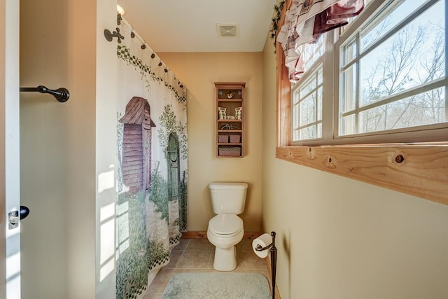 bathroom featuring toilet and tile patterned flooring