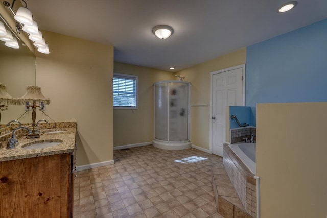 full bath featuring a garden tub, double vanity, baseboards, a sink, and a stall shower