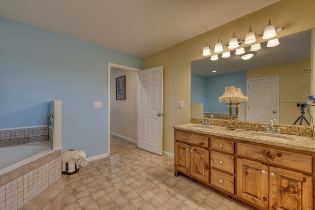 bathroom featuring double vanity, baseboards, a relaxing tiled tub, and a sink
