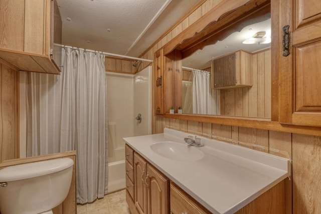 bathroom with a textured ceiling, shower / bath combo, vanity, tile patterned floors, and toilet