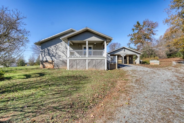 view of front of house with dirt driveway, a front lawn, covered porch, and a carport